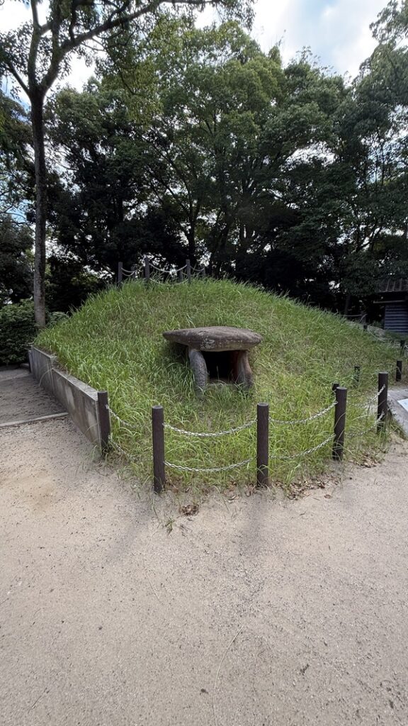 古墳。みどりの草に覆われていて石棺がのぞいている